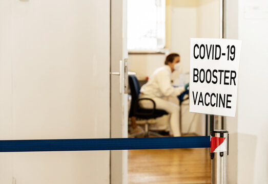 Covid 19 Coronavirus Booster Vaccination, Third Vaccination, Waiting Area In Front Of The Doctor's Office In A Vaccination Center, Sign That Says Covid-19 Booster Vaccination