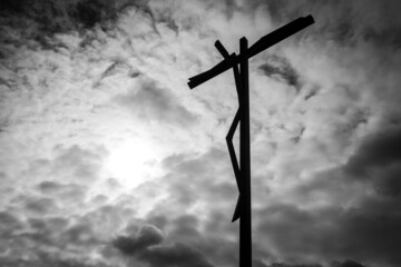 Estatua de cristo na cruz com ceu nublado por fundo perto e branco