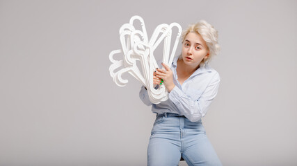 Girl holding a bunch of clothes hangers in her hands on a white background