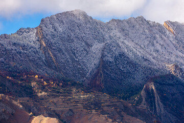 Fantastic high rocks. Autumn landscape with steep mountain peaks. First snow in Caucasus Mountains in Dagestan, Russia. Panoramic view of the Caucasian ridges and sharp rocks