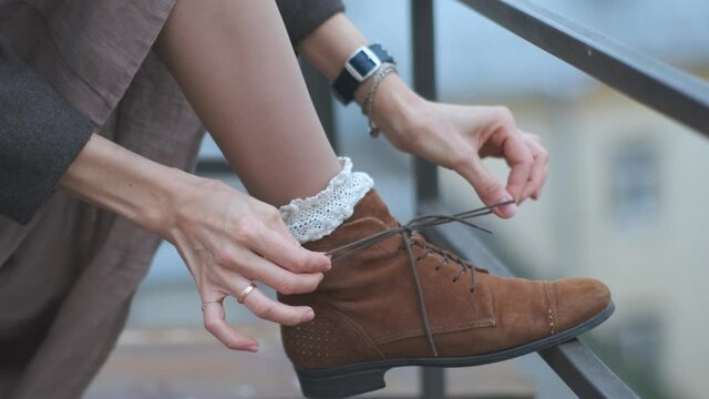 close-up woman straightens vintage socks and boots on her leg
