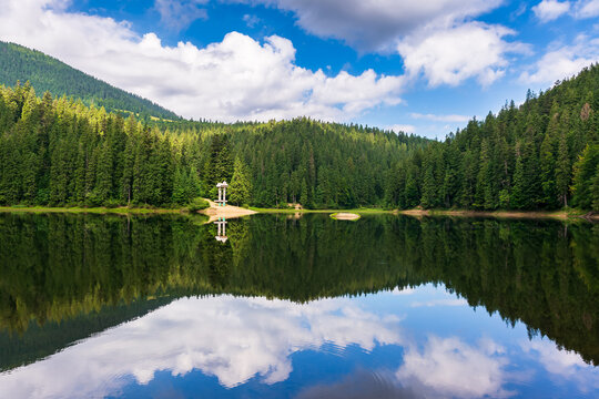 landscape with mountain lake in summer. forest and cloud reflection in the water. scenic travel background of synevyr national park, ukraine. beautiful nature scenery. green outdoor environment