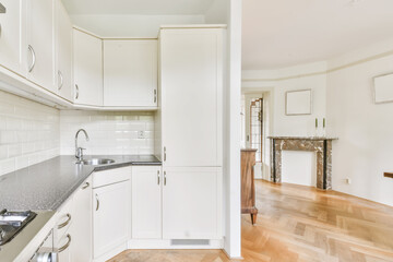 Interior of spacious light kitchen with modern white furniture in light apartment