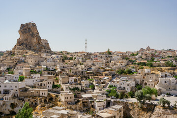 Fototapeta na wymiar Cappadocia, Turkey - 20 July 2021. Day view of Goreme town with blue clear sky on horison. Famous center of balloon fligths