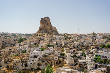 Fototapeta na wymiar Cappadocia, Turkey - 20 July 2021. Day view of Goreme town with blue clear sky on horison. Famous center of balloon fligths