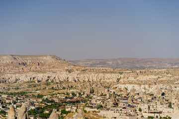 Cappadocia, Turkey - 20 July 2021. Day view of Goreme town with blue clear sky on horison. Famous center of balloon fligths