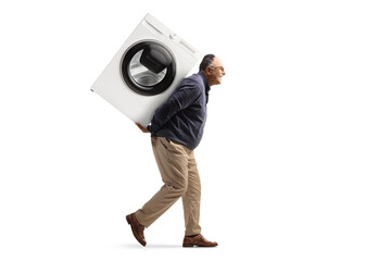 Full length profile shot of a mature man carrying a washing machine on his back