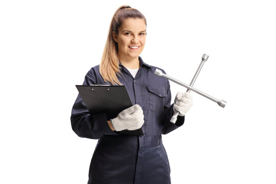 Female car mechanic worker in an overall pants holding a lug wrench and a clipboard