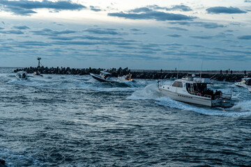 Naklejka premium Sport Fishing boats racing out to sea at sunrise 