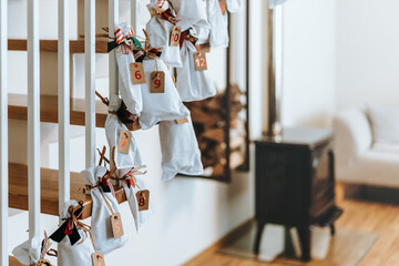 Advent calendar. White surprise bags decorated with colorful red-green Christmas ribbons. Handmade...