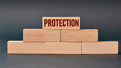 PROTECTION - word on wooden blocks on dark background