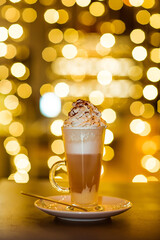 latte coffee with cream, on the background of lights, in a transparent glass