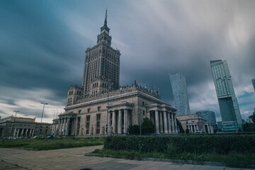 Fototapeta na wymiar Palace of art and culture in Warsaw, Poland on a cloudy and rainy afternoon. Clouds are seen rushing past the sky. Beautiful portrait of polish historical sight