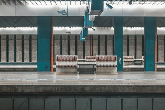Empty train platform at Warsaw Centralna train station. Visible benches for passengers, pillars and platforms. Modernistic photo.