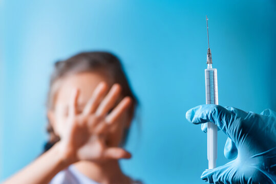 The child was given a vaccine.Female doctor or nurse trying to give shot or vaccine against virus to a scared patient. Angry and distrustful patient refuses to receive it.
