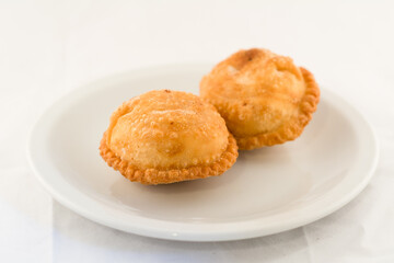dos tartas de masa rellena fritas en plato blanco