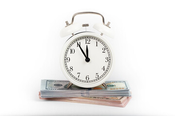 alarm clock standing on piles of money. money and economy concept. isolated on white background.