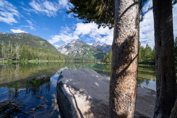 Fototapeta na wymiar Taggart Lake in Grand Teton National Park, framed by rocks on a sunny calm morning
