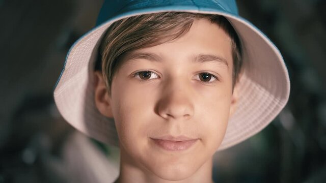 portrait of a happy teen boy in a hat looking at the camera, teen boy 12 years old, cinematic shot