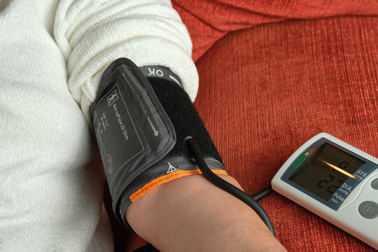 unrecognizable old woman taking blood pressure