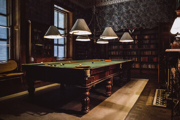 Snooker table setup with balls and pool cue in an old room