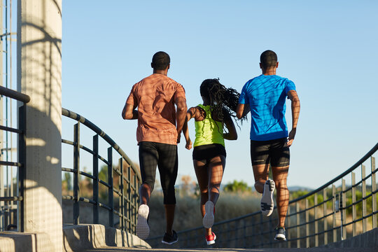 Mixed group of anonymous black athletes running away 