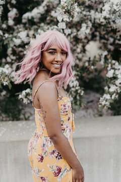 A young african amrican woman wearing a pink wig