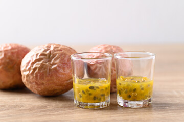 Overripe passion fruit and juice on wooden background