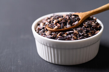Thai purple glutinous rice grain in bowl with spoon, Organic and healthy food