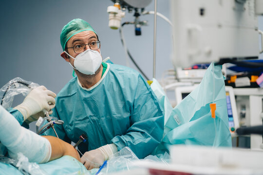 Surgeon operating shoulder of patient
