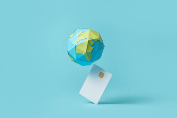 Paper globe balancing on debit card
