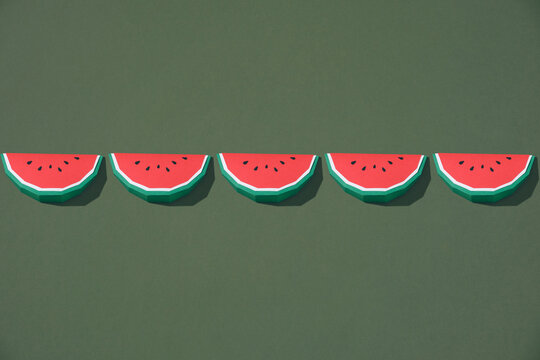 Paper watermelon slices on green background. - Powered by Adobe