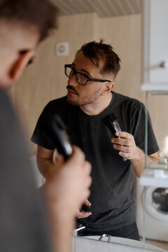 a nice man shaves with an electric razor