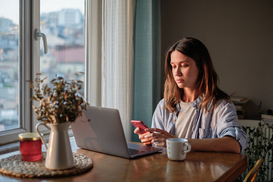 Woman scrolling on her smartphone at home
