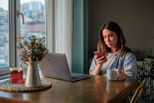 Woman scrolling on her smartphone at home