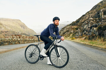 Road cyclist admiring view of mountain road
