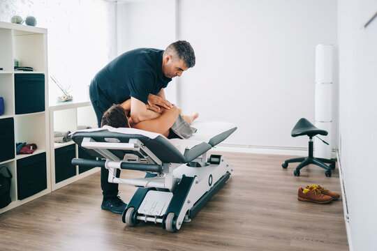 Osteopath pressing hands on client
