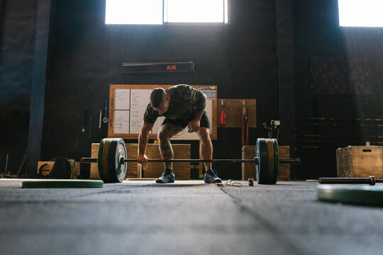 Man preparing to lift a heavy bar in the gymnasium