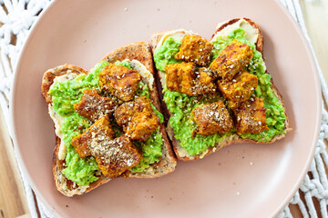 vegan avocado toast topped with marinated tempeh and dukkah, healthy plant-based food