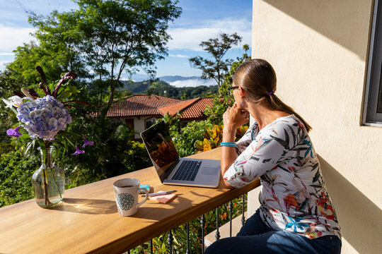 Businesswoman looks out over valley in remote office