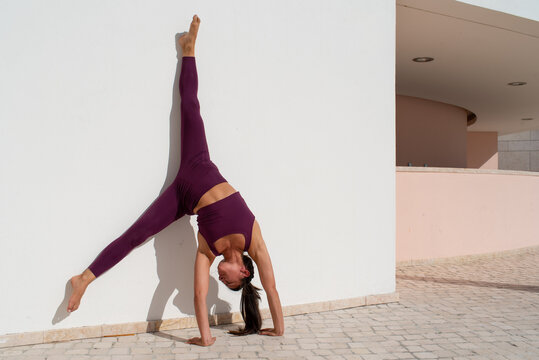 Split leg on the white wall Asana pose
