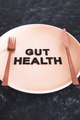 gut health text on dining plate with fork and knife, healthy nutrition and research about the...