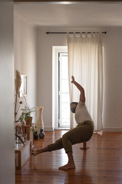 Anonymous man practicing acro yoga in his living room