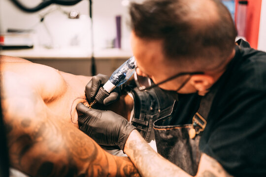 Tattoo artist working at his studio
