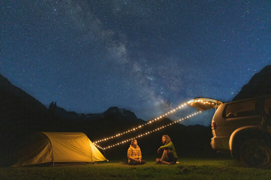 Couple sitting in camping under the starry sky
