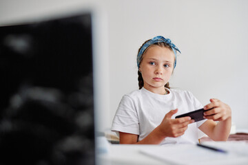 Little girl customizing gadget at home 