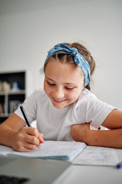 Cheerful girl writing essay 