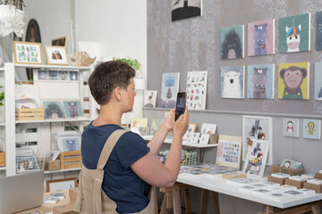 Young Artist Taking Pictures Of Canvas On The Wall