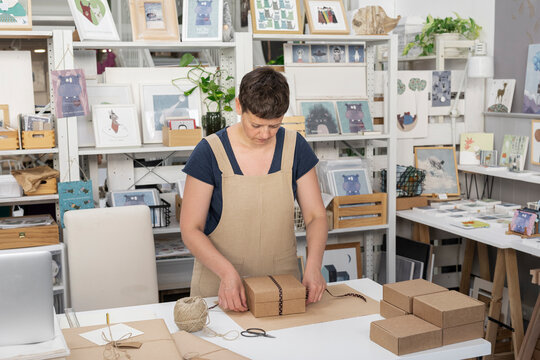 Young Artist Wrapping Package To Sell Online 