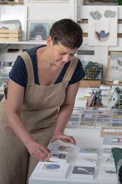 Young Illustrator Selecting Canvas To Hang On The Wall 